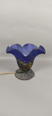 lampe en verre bleu en forme de fleur, avec un cordon jaune, sur fond blanc