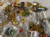 a pile of gold and silver lapel pins on a table