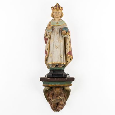 a wooden statue of a woman with a crown on a pedestal