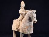 une vieille statue représentant un homme à cheval sur fond noir