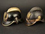 pair of helmets with eagle emblems on them against a black background