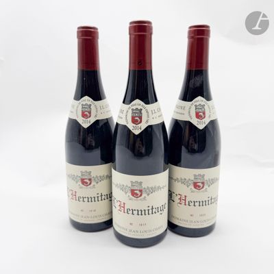 trois bouteilles de vin rouge posées l'une à côté de l'autre sur une surface blanche
