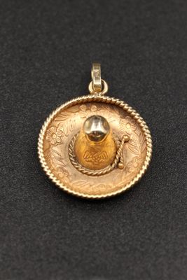gros plan d'un pendentif en or sur une surface noire