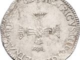a close up of a silver coin with a cross on it