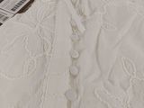 the shirt is white and has a lace pattern on it