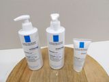 three bottles of lotion sitting on top of a cutting board