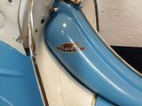 a blue and white motor scooter parked in a garage