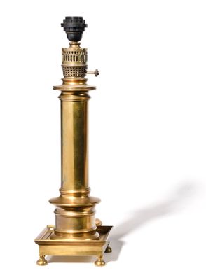 une lampe de table en laiton ancien, surmontée d'un abat-jour noir