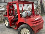 a red forklift truck parked in front of a building
