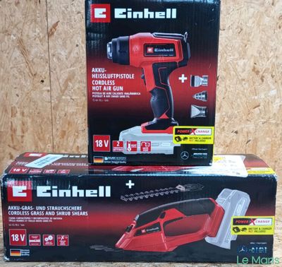 two boxes of electric tools sitting on top of a wooden table