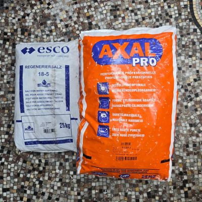 a bag of gravel next to a bag of gravel on a tiled floor