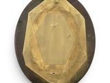 a picture of a gold and black plate on a white wall