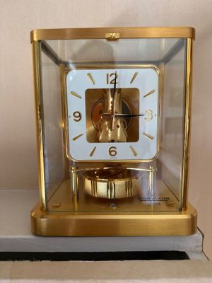 une horloge en or posée dans une vitrine, sur une table
