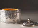 a silver container with a lid sitting on a table