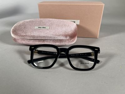 des lunettes sont posées sur une table à côté d'une boîte et d'une paire de lunettes
