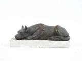 statue représentant un chien couché sur une surface blanche