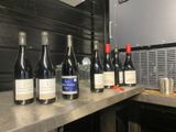 several bottles of wine are lined up on a counter in a kitchen