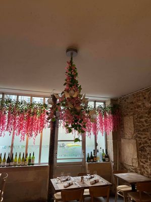 des fleurs suspendues au plafond dans un restaurant, près d'une fenêtre