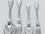 four silver spoons and two silver spoons on a white surface