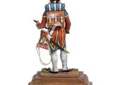 statue of a man in uniform with a drum and a hat on a wooden base