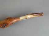 a pipe that is sitting on a table next to a piece of wood