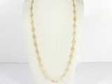 a gold chain necklace on a mannequin display with a white mannequin