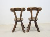 two wooden chairs sitting next to each other on the floor