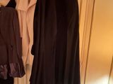 two coats hanging on a clothes rack in a closet