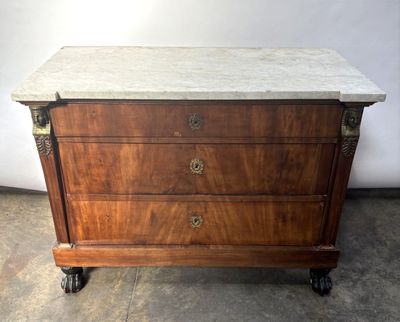 an antique chest of drawers with marble top on casteors