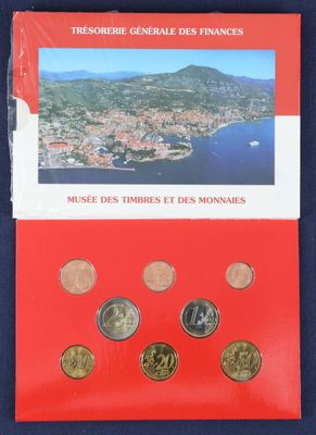 un livret rouge sur lequel figure une image représentant une ville et des montagnes