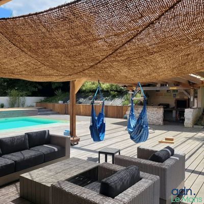 un espace de vie extérieur avec une piscine et un hamac
