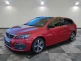 une voiture rouge est garée dans une pièce au sol en damier