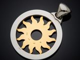 a close up of a silver and gold sun pendant on a black background