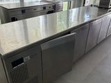 une grande cuisine équipée d'appareils électroménagers en inox et dotée d'une grande fenêtre