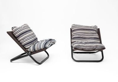 pair of lounge chairs with striped cushions on them against a white background