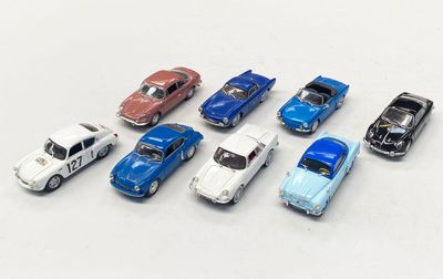 plusieurs petites voitures sont alignées sur une surface blanche