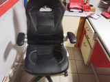 a black office chair that is in a small room