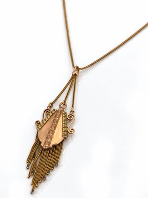 Gros plan sur un collier en or orné d'un oiseau