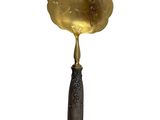 an antique brass spoon with a wooden handle and handle