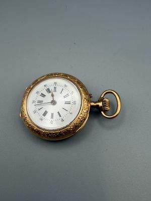 a gold pocket watch with roman numerals on it