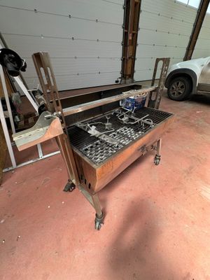 une voiture garée dans un garage, à côté d'une table sur laquelle se trouve un barbecue