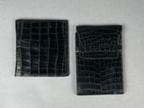une paire de porte-cartes de visite en cuir d'alligator noir sur un fond blanc