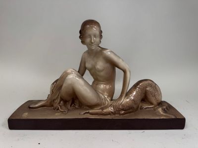 statue en bronze d'une femme assise sur un rocher avec un chien