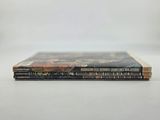 a stack of three books sitting on top of a white table