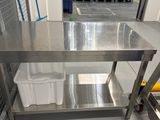 une table en acier inoxydable au milieu d'une pièce