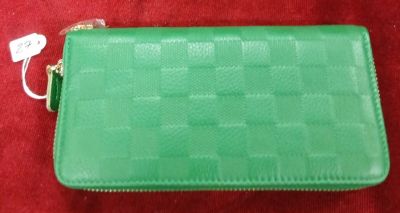 une photo d'un sac à main vert posé sur un tapis rouge
