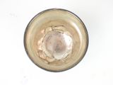 a glass with a liquid inside of it on a table