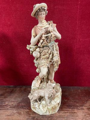 a figurine of a woman holding a cat on a rock