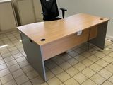 an empty office with a desk and chair in front of a window