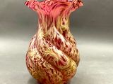 un vase rouge et jaune posé sur une surface grise